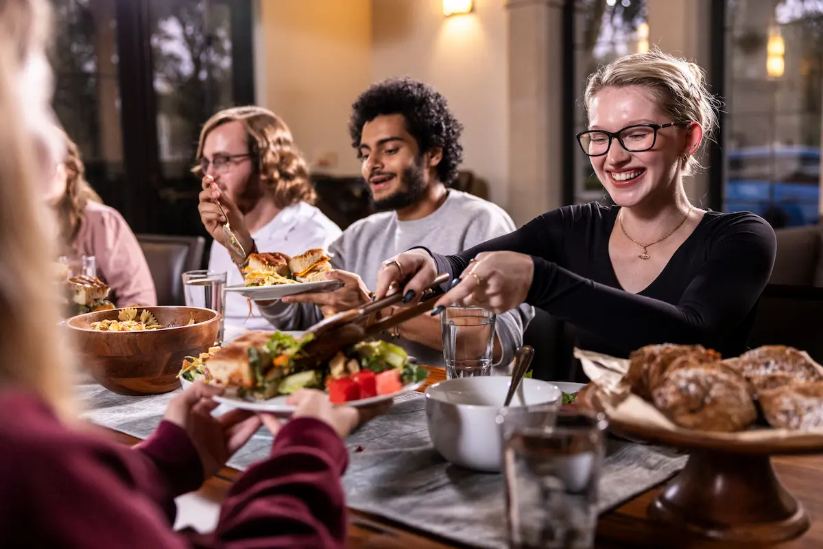 Candid photograph of people sharing a meal at a Breaking Bread table